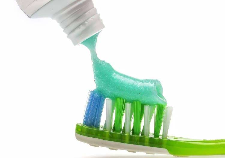 Nanášení zubní pasty na zubní kartáček.
